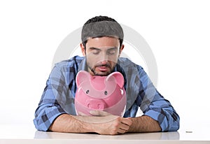 Sad worried man in stress with piggy bank in bad financial situation