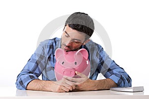 Sad worried man in stress with piggy bank in bad financial situation