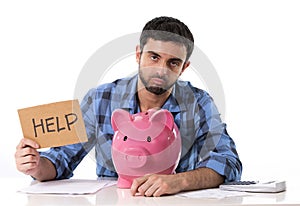 Sad worried man in stress with piggy bank in bad financial situation