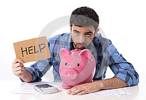 Sad worried man in stress with piggy bank in bad financial situation