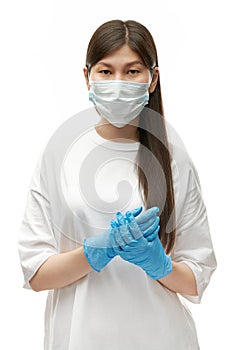 Sad young asian girl in medical mask and blue gloves waiting quarantine end