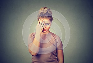 Sad young beautiful woman with worried stressed face expression looking down