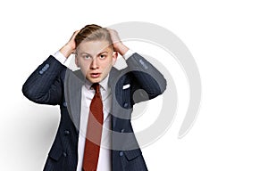 Sad young businessman, student, diplomat holding hands on head isolated on white studio background. Human emotions