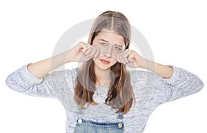 Sad young fashion girl in jeans overalls isolated