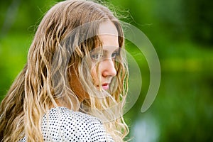 Sad young fashion woman with long curly hairs outdoor