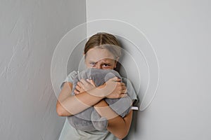 Sad young girl crying and looking at camera at home