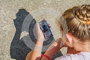 Sad Young girl holding in hand black modern smartphone with broken glass screen