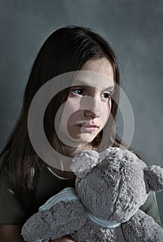 Sad young girl with toy