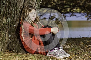 Sad young girl by tree photo