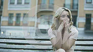 Sad young lady sitting alone and crying bitterly, relationship or health problem