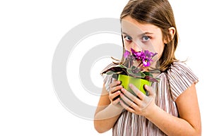 Sad young little girl holding flower pot mourning family loss