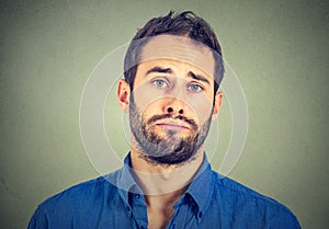 Sad young man isolated on gray wall background