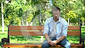 Sad young man sitting alone park bench, breakup crisis, problem hopelessness photo