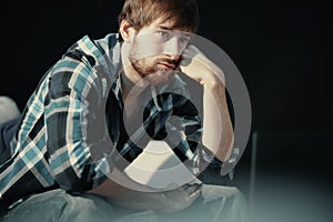 Young man sitting on the couch looking into space