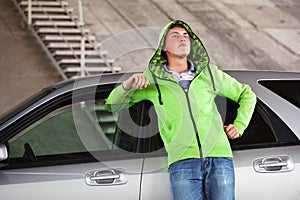 Sad young man standing next to his car outdoor