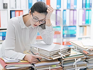 Sad young office worker overloaded with work