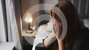 Sad young readhead woman crying on the bed - portrait space copy