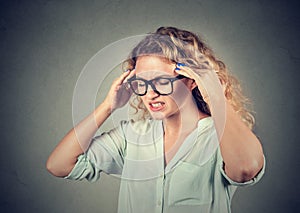 Sad young woman in glasses with worried stressed face expression