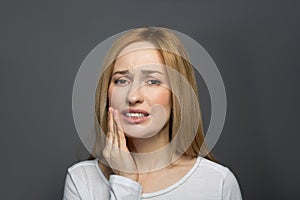 Sad young woman having toothache photo