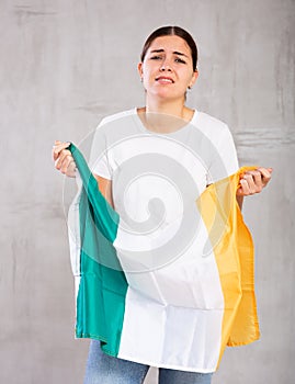 Triste giovane donna possesso irlanda bandiera contro 