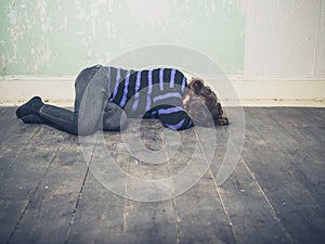 Sad young woman lying on floor