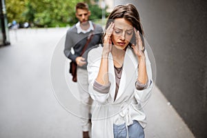 Sad young woman and man outdoor on street having relationship problems