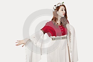 Sad young woman in old-fashioned princess costume looking away against gray background