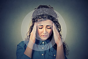 Sad young woman with worried stressed face expression having headache