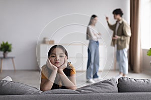 Sad youngsters girl looks at camera, young asian couple quarreling at home in living room interior