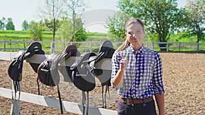 Saddles Hanging On The Wooden Fence - Girl In The Foreground Making Thumbs up