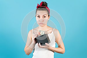 Sadly, a young woman pulls dollars out of a box of cash