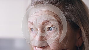 Sadness in the blue eyes of an old woman. Depression and anxiety at old age