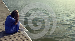 Sadness woman sitting by the river on pier. introvert, fatigue and depression concept with copy space