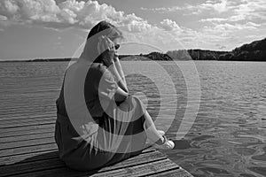 Sadness woman sitting by the river on pier. introvert, fatigue and depression concept with copy space