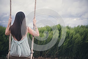 Sadness woman on swing in garden