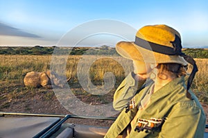 Safari holiday. Wildlife photography in Kenya, Tanzania. Blond woman watching african elephants from roof of a safari