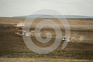Safari jeeps crossing Serengeti, Tanzania photo