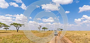 Safari tourists on game drive with Jeep car in Serengeti National Park in beautiful landscape scenery, Tanzania, Africa