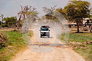 A safari van on a dirt road in the panoramic savannah grassland landscapes of Amboseli National Park in Kenya