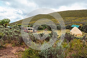 A safari vehicle against a Mountain background at Road Head campsite in Chogoria Route, Mount Kenya National Park, Kenya