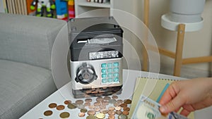 Safe deposit box for storing money. Woman putting hundred-dollar bills in a small safe
