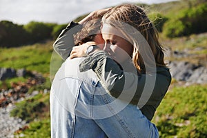 Safe in his warm embrace. an affectionate young couple spending time together outdoors.