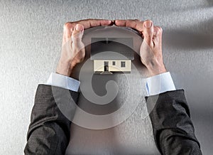Safe insulation home with businessman hands protecting and securing roof photo