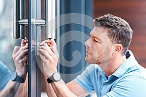 Safe and secure. a handsome mature locksmith installing a lock.