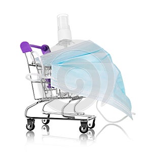 Safe shopping concept. Shopping cart wearing a mask and sanitizer isolated on white