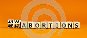 Safe or unsfe abortions symbol. Concept words Safe abortions and Unsfe abortions on wooden cubes. Beautiful orange table orange