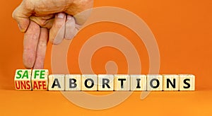 Safe or unsfe abortions symbol. Concept words Safe abortions and Unsfe abortions on wooden cubes. Doctor hand. Beautiful orange