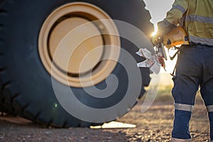 Safe work practises miner haul truck driver wearing work uniform safety glove holding hard hat locks prior start