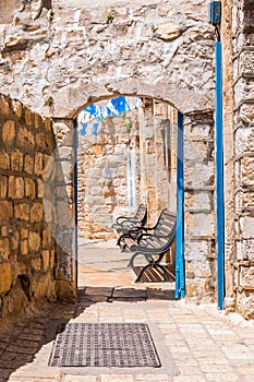Safed street, bystreet, alley, backstreet with benches, ancient stone walls, arcs and blue white decorations