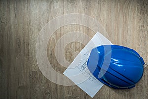 Safety blue helmet and home construction plan in dark abstract tone, architecture or industrial equipments, with copy space